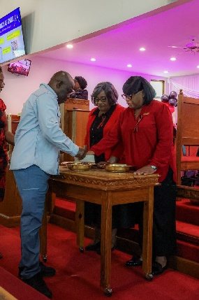 Stewards at the offering table at the front of the sanctuary, receiving the offering