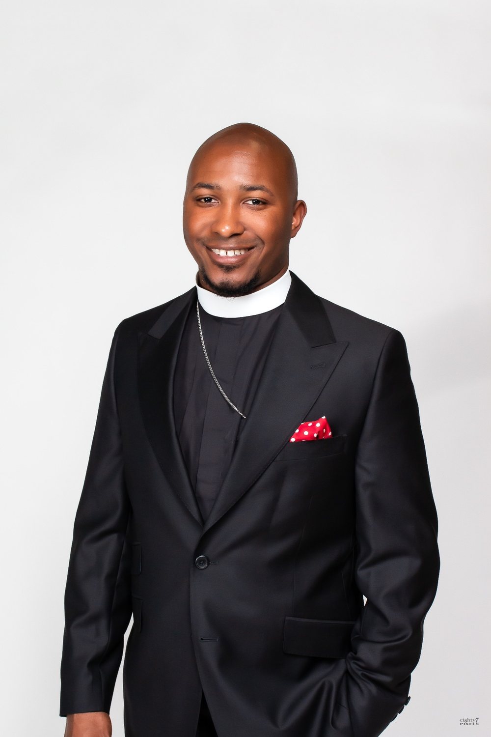 Rev. L. Christopher Lewis smiling, in a black suit and clerical collar